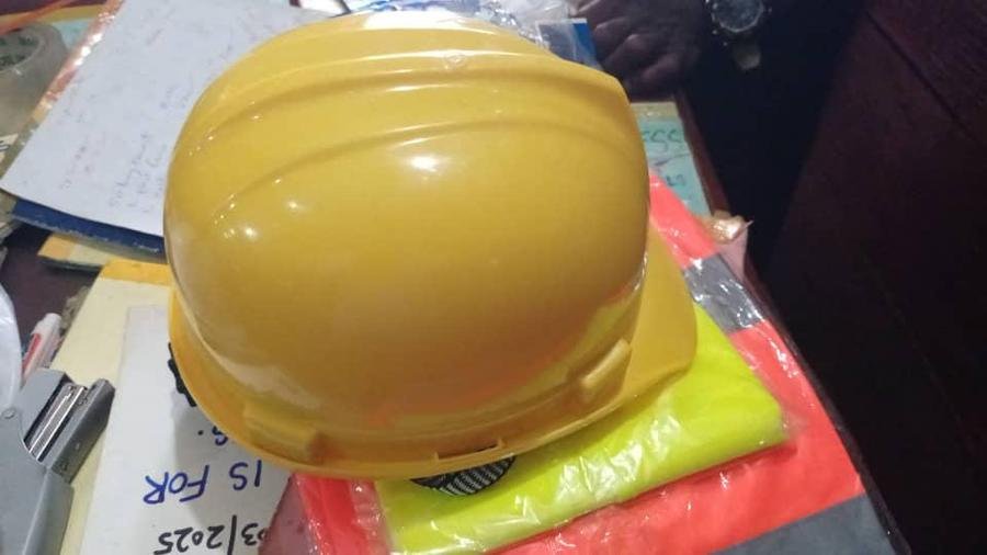A yellow safety helmet and hi-vis vests held by LAMM Investment Company.